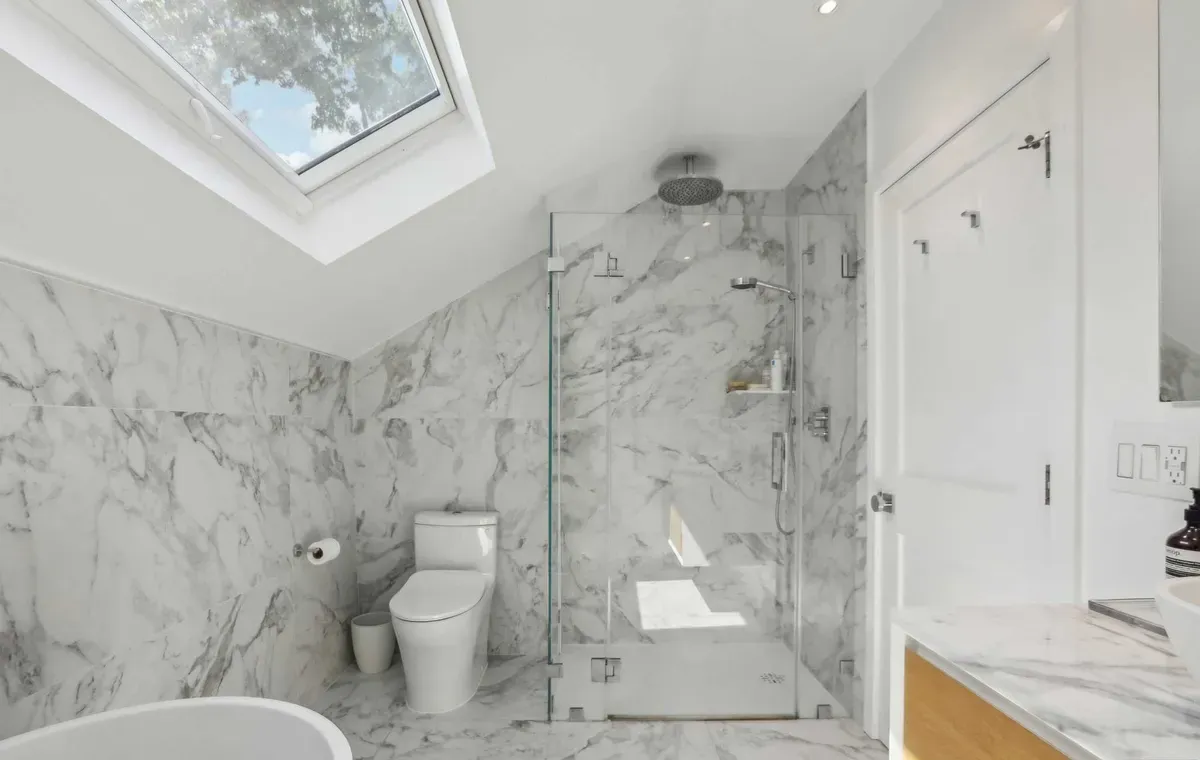 Marble bathroom with skylight and glass shower
