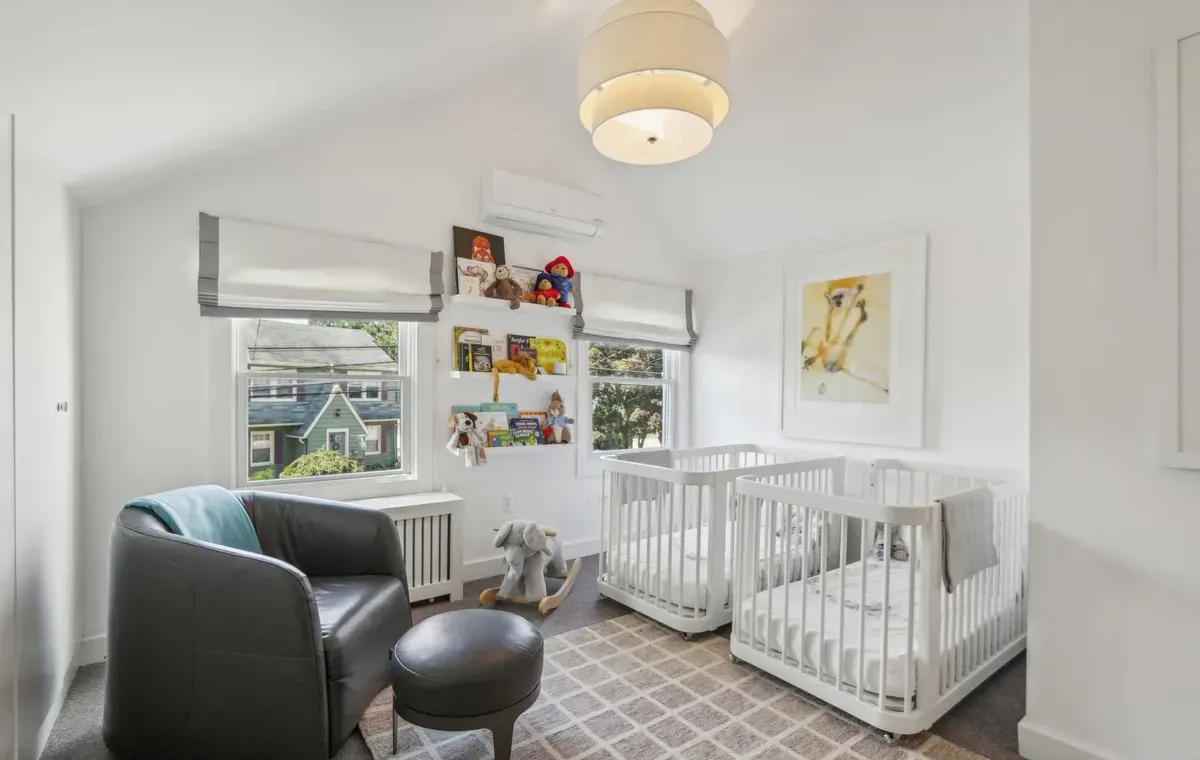 Nursery with twin cribs and built-in bookshelf